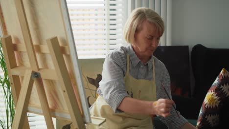 video of senior artist finishes painting a picture