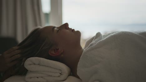 young woman getting head massage at a lakeside hotel