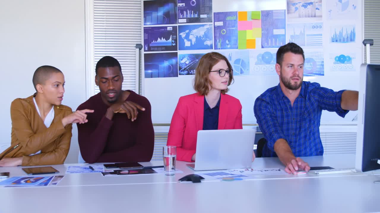 Front view of mixed race business team discussing over computer in modern office 4k