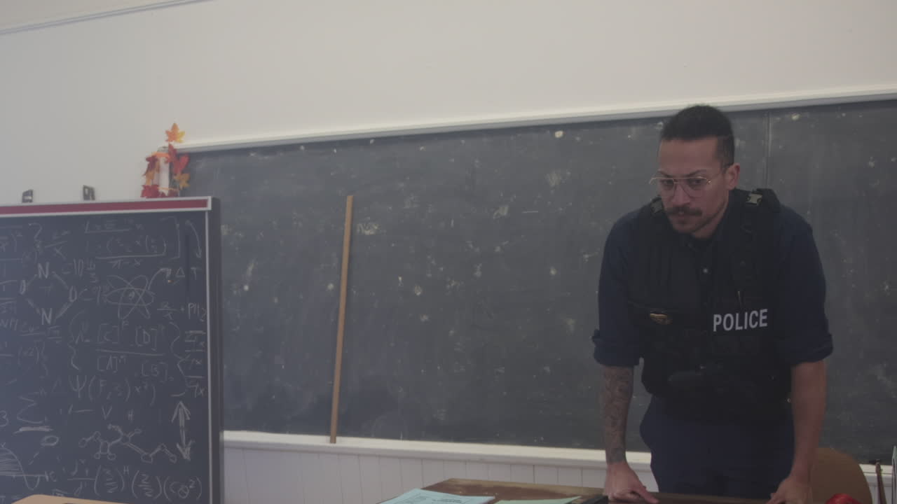 oficial de policía en una sala de clases en la escuela