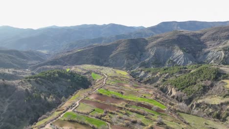 toma aérea de tierras de cultivo situadas en la ladera de una colina cerca de las montañas