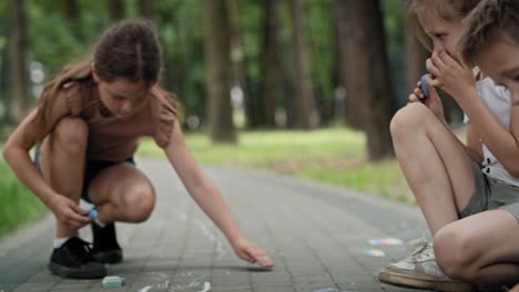 Gruppe-Von-Kindern,-Die-An-Einem-Sommertag-Mit-Kreide-Färben.