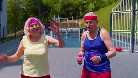 Senior-grandmother-grandfather-working-out-on-playground-doing-dancing-sport-stretching-exercising