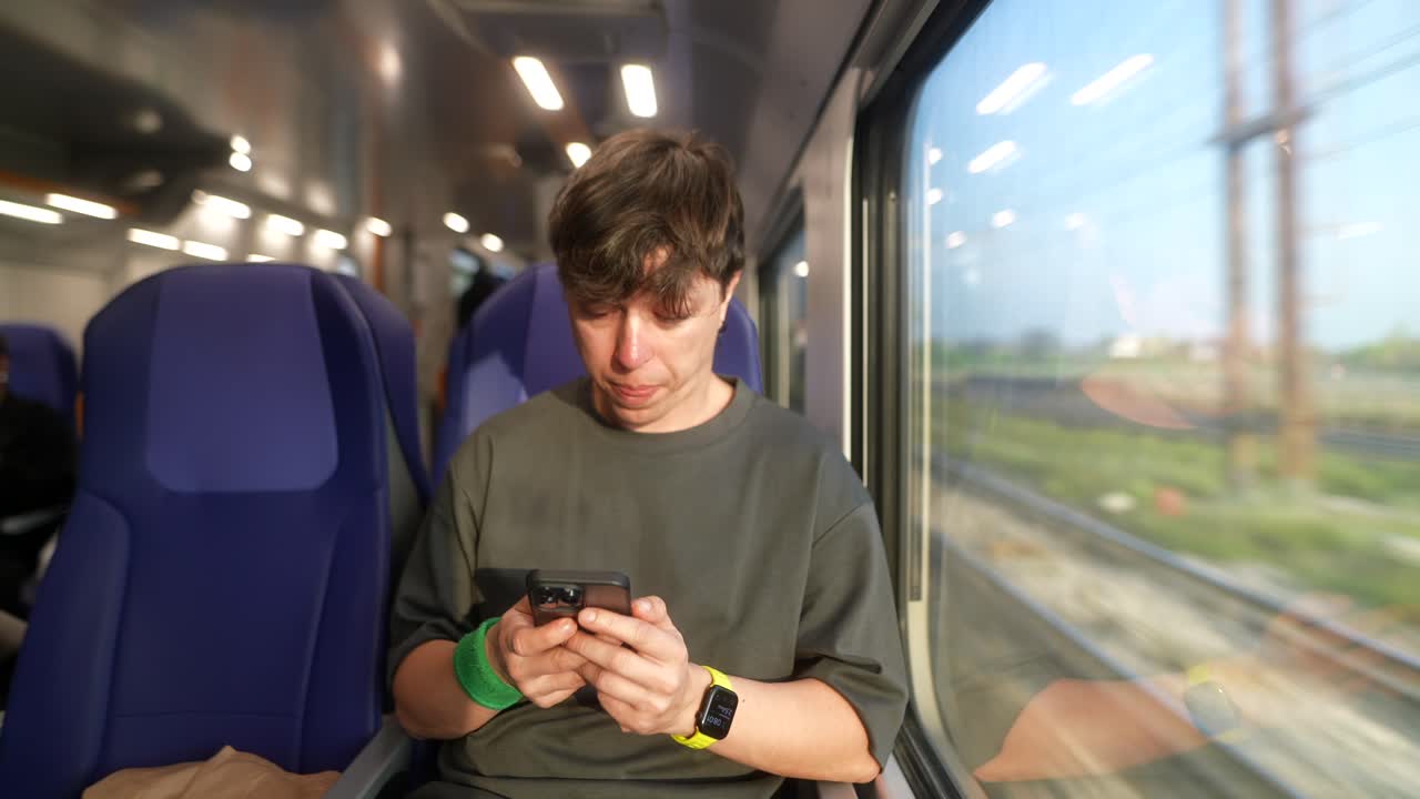 기차에서 스마트폰을 사용하는 남자