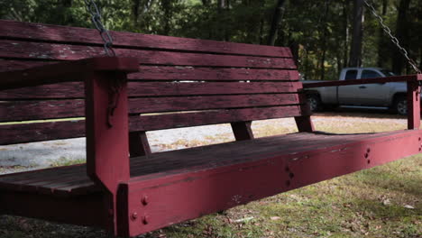 red bench swing moving in the wind