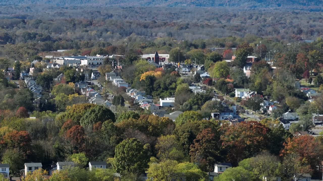 Aerial wide shot of American city neighborhood with colored trees in autumn season. Wide shot