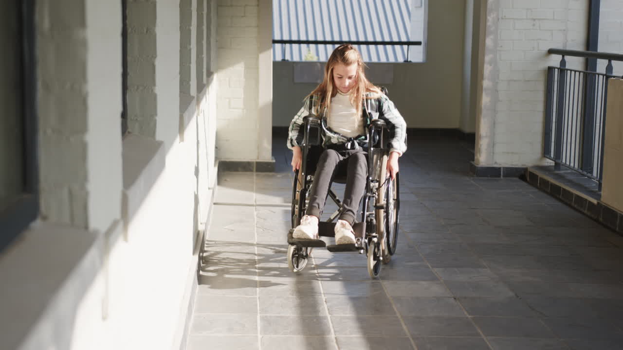 Young girl in wheelchair navigating school hallway, determined and independent