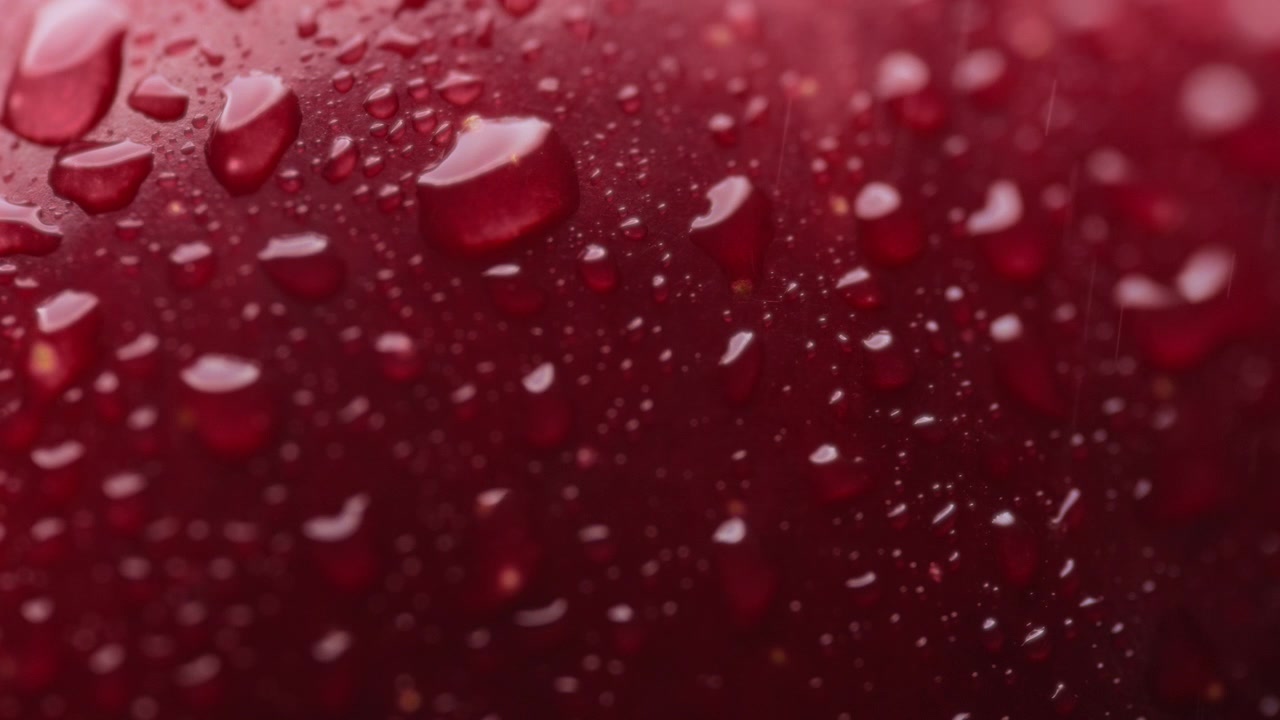 Acqua spruzzata sulla superficie di una mela rossa