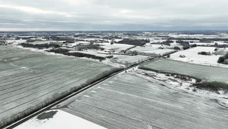 Aerial-drone-shot-over-snowy-landscape-under-an-overcast-sky