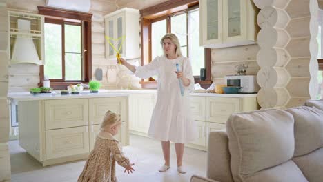 mother and daughter playing bubbles in kitchen