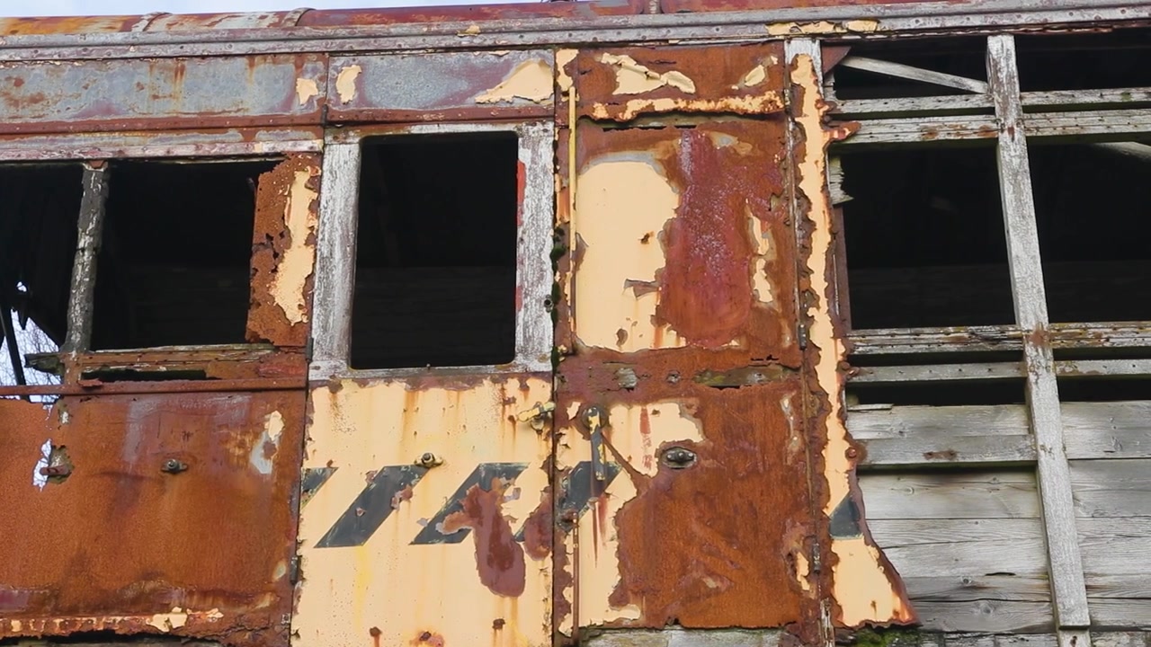 Camera glides across a rusted, peeling carriage panel, ideal for grunge textures