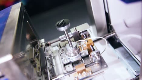 hands operating microscope specimen on mechanics, close up