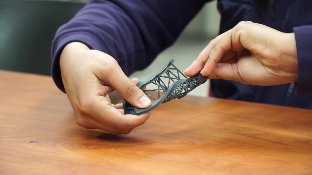 Female manufacturing engineer testing flexibility of 3D printed material, hands close up
