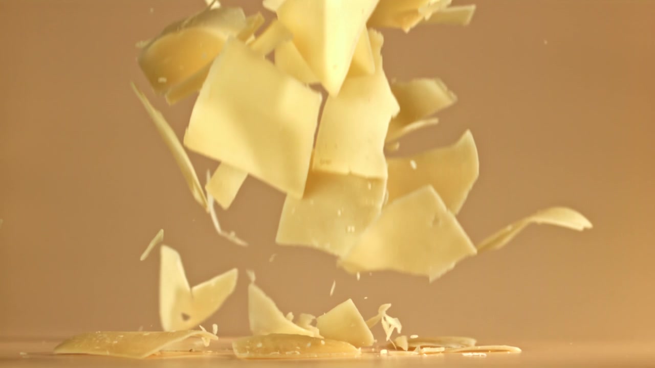 White Chocolate Flakes Falling in Slow Motion on a Beige Background