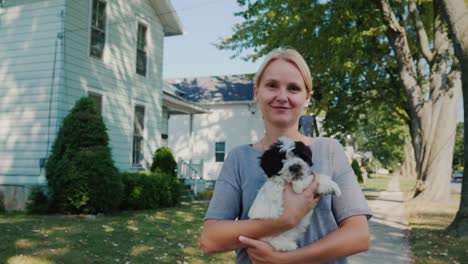 middle-aged woman is walking with a dog in her arms