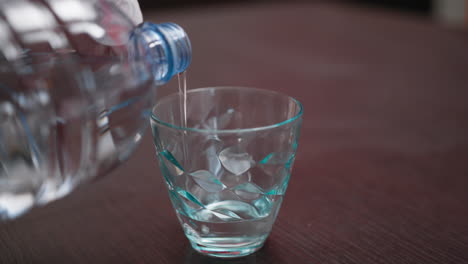 pour water into a glass at the table for well-being