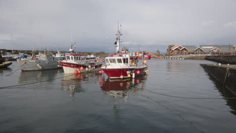 Boats-in-Newhaven-Harbour-at-high-tide-on-an-overcast-day-in-Edinburgh,-Scotland,-UK