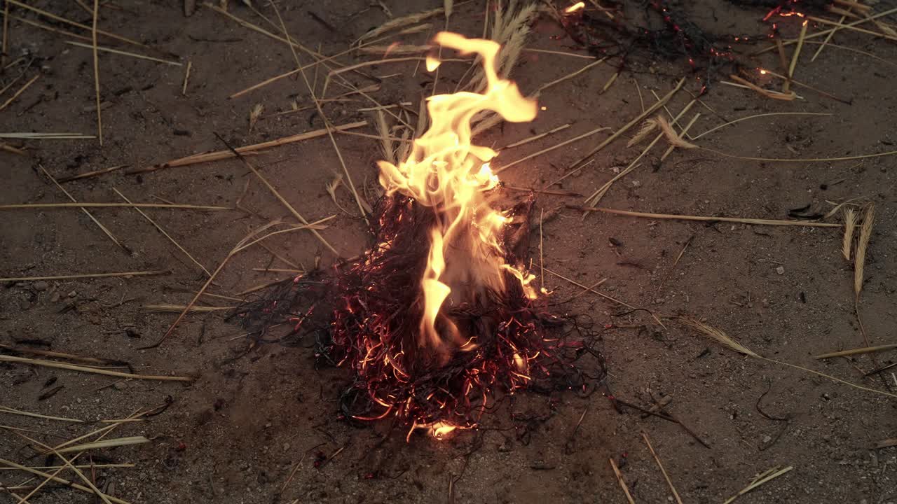 Straw ignited on dirt ground