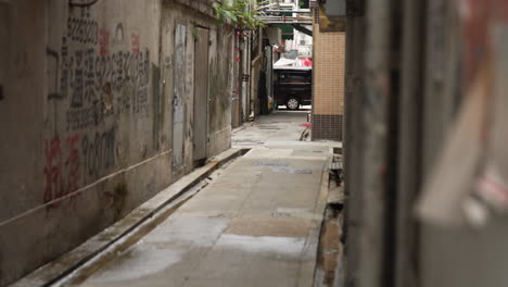 Long-shot-of-two-asian-women-walking-down-empty-alleyway-in-Hong-Kong,-China
