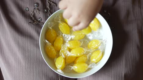 노란색으로 감싸진 단단한 사탕의 그에 손을 고