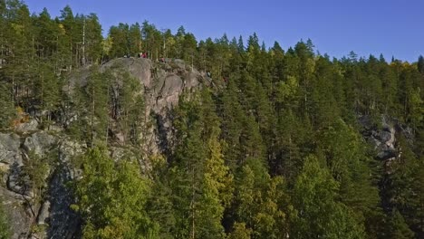 montaña en un bosque, parque nacional de finlandia, gente y turistas en la cima