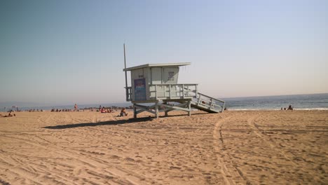 video estático de 4k de una cabaña azul de salvavidas en la playa de venice en los ángeles, california