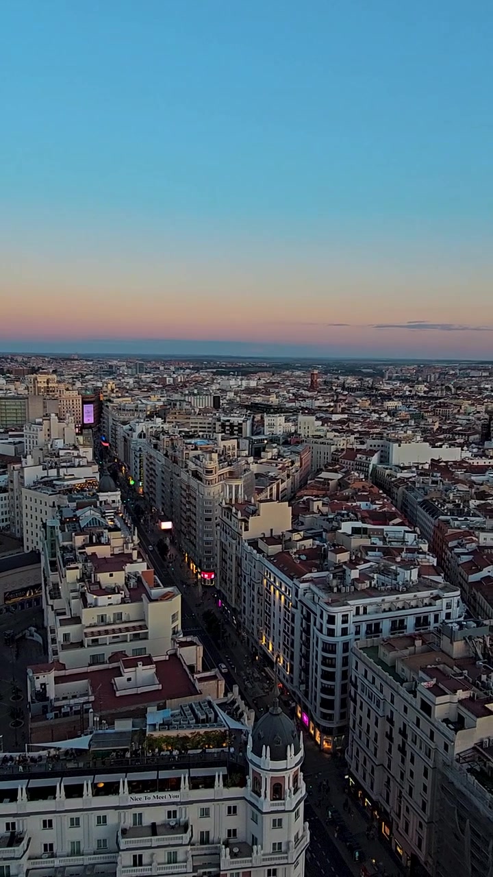 Vista panoramica sulla città di Madrid da un punto di osservazione a 360 gradi su un tetto, con un vasto skyline urbano, architettura storica, vista del tramonto e un'atmosfera europea dinamica che crea filmati di viaggio cinematografici.