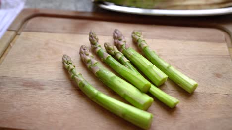 Six-Asparagus-shoots-on-wooden-cutting-board