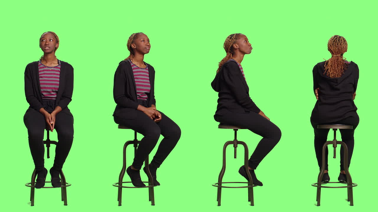 Woman sitting on a stool in front of a green screen