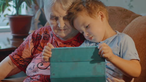 grandmother and grandson use tablet at home