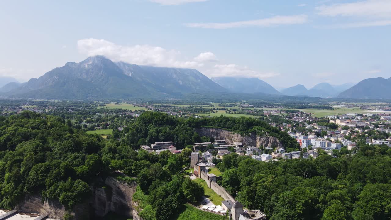 Panoramic drone shot of Salzburg, Austria with forested hills and Alpine views