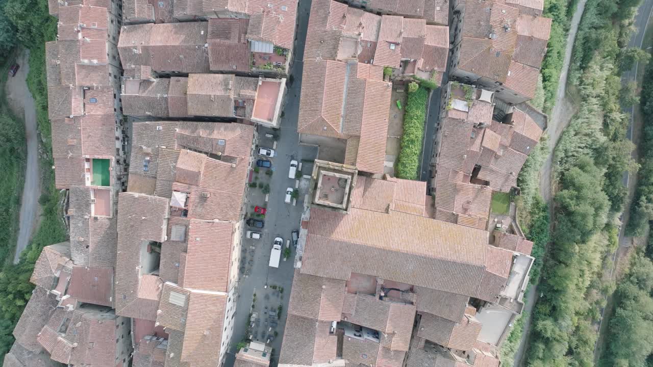Top Down Aerial Drone view of the hilltop Medieval town of Pitigliano, Tuscany in morning light, with red tile roofs and old buildings, in 4K
