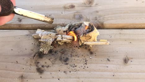 toma de primer plano de prender fuego al papel en un tablón de madera