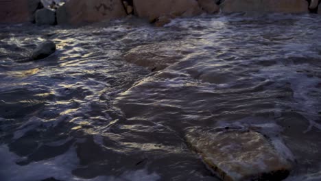 olas rompiendo sobre rocas en la noche