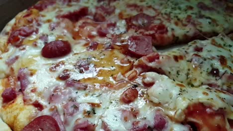 Pizza-Perfecta,-Queso-Cheddar-Extra-Fundido,-Salami-Extra-Y-Aderezos-De-Pepperoni-Servidos-Calientes,-Rebanados-Con-Un-Cuchillo-De-Sierra-De-Acero-Inoxidable