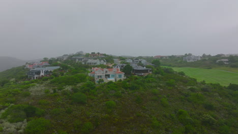 Aerial-view-of-luxury-residences-on-hill.-Slide-and-pan-shot-of-hazy-weather-in-town-outskirts.-Port-Elisabeth,-South-Africa