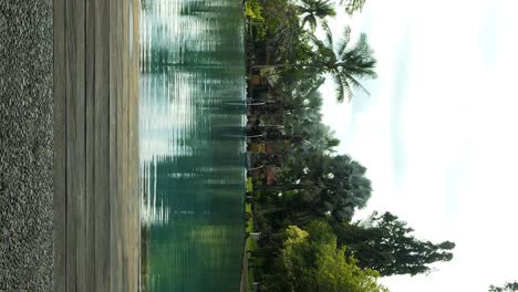 Vertikale-Aufnahme-Eines-Wunderschönen-Swimmingpools-In-Einem-Luxushotel-Auf-Bali,-Indonesien,-An-Einem-Wunderschönen-Morgen-Während-Einer-Großartigen-Reise