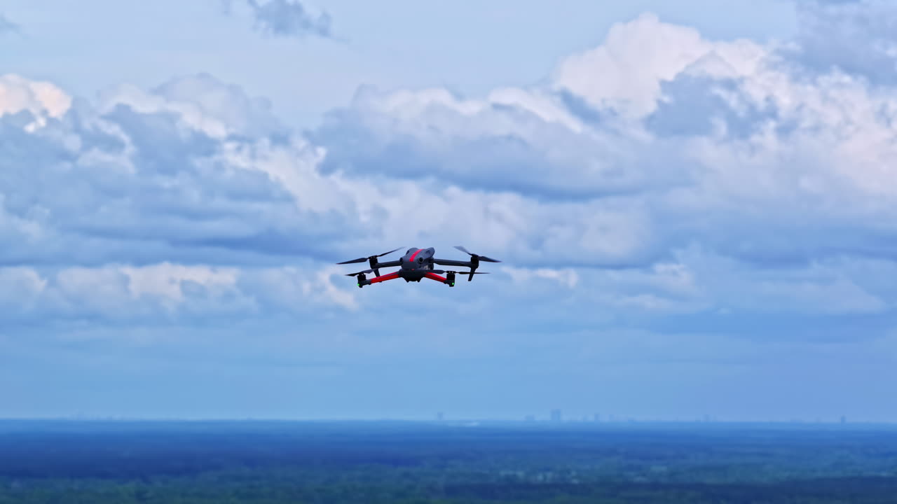 Drone flying mid-air above forest under dramatic cloudy sky
