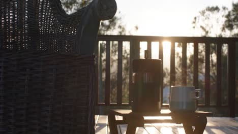 coffee pot and cup of hot coffee at log cabin over sunset, slow motion