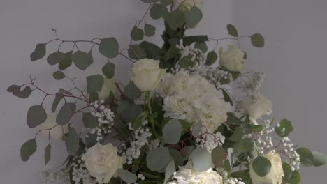 white floral arrangement with roses, eucalyptus, and baby's breath in soft lighting