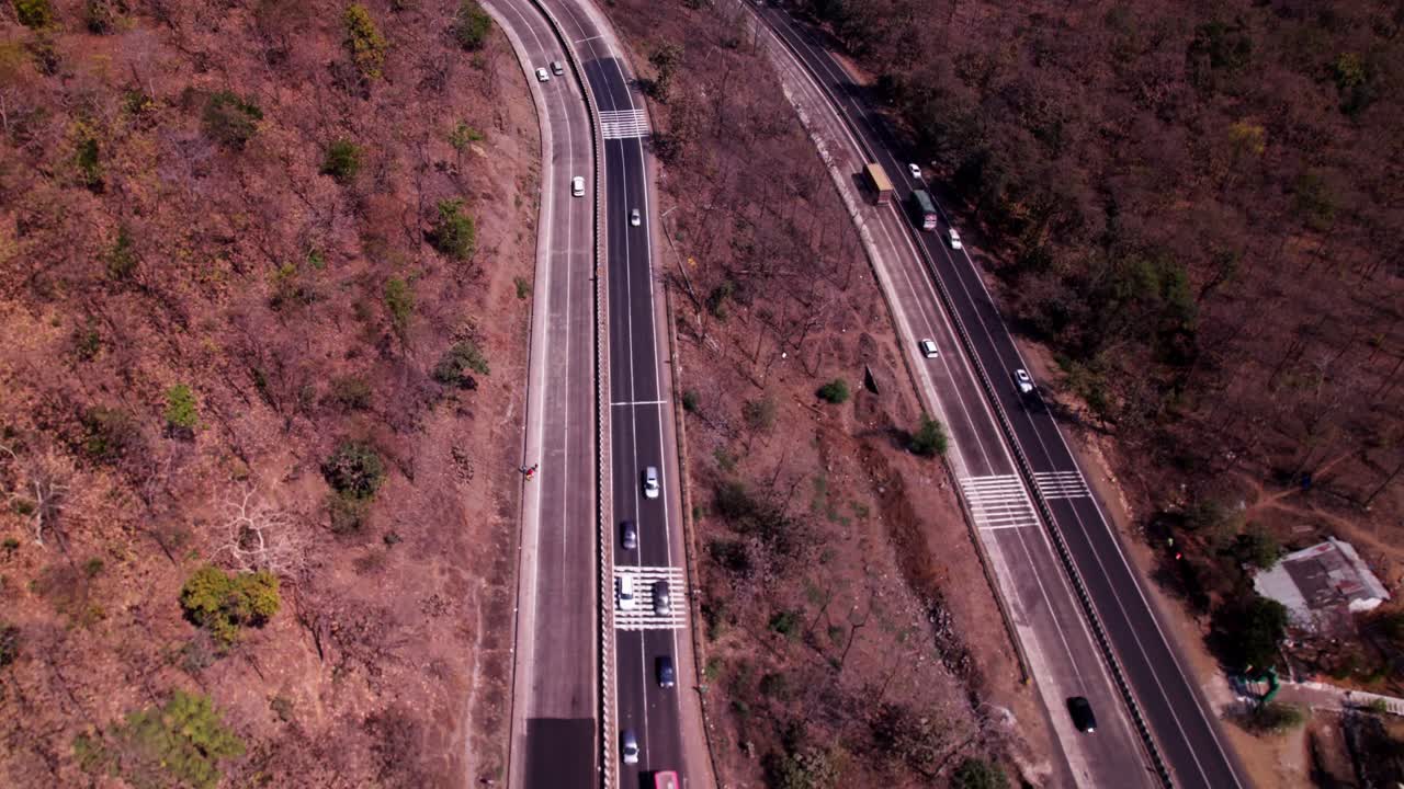 Ghat road with crop fields lands and hill mountainous at siluwa ghati, Ramanpur, Siluwa, Hulki, Madhya Pradesh, india. day time, push in, tilt up, drone shot, 4k.