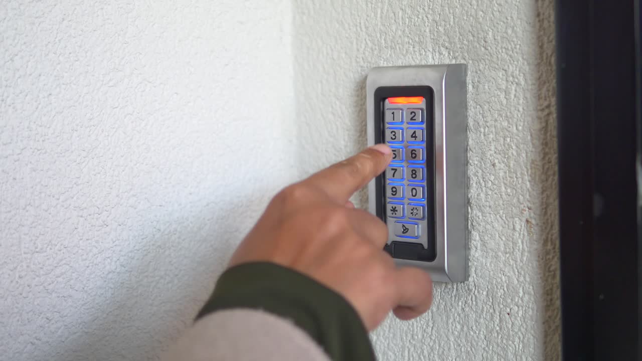 Person entering a code on an access control keypad