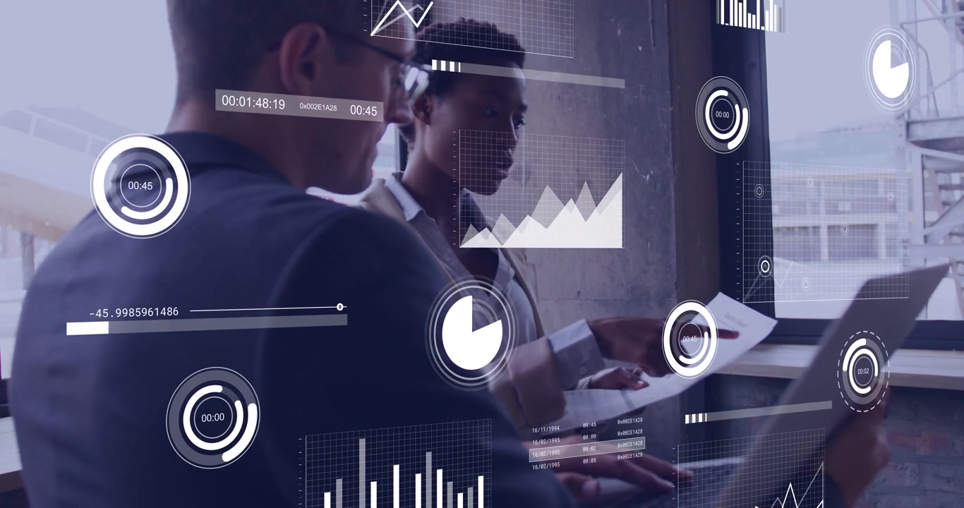 Right woman pointing at paper, left man typing while tech overlays appearing over laptop for review