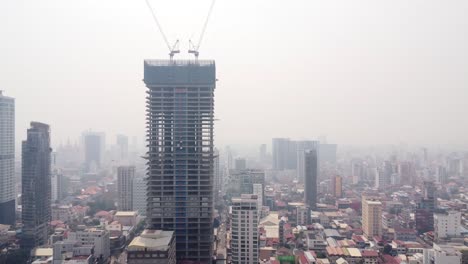 urban skyline buildings construction in phnom penh city covered in hazy sky due to air pollution and climate change, drone view