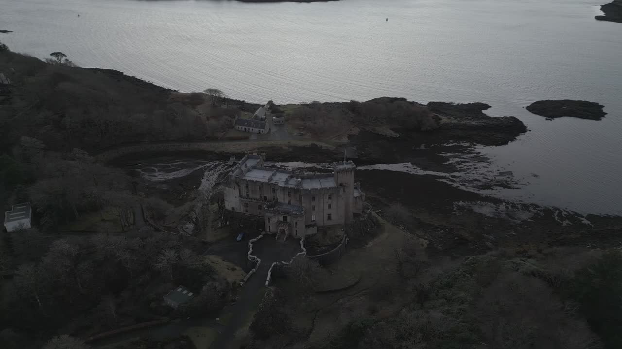 스카이 섬에 있는 던베건 성 (dunvegan castle) 은 황혼에 나무와 물로 둘러싸여 있다.