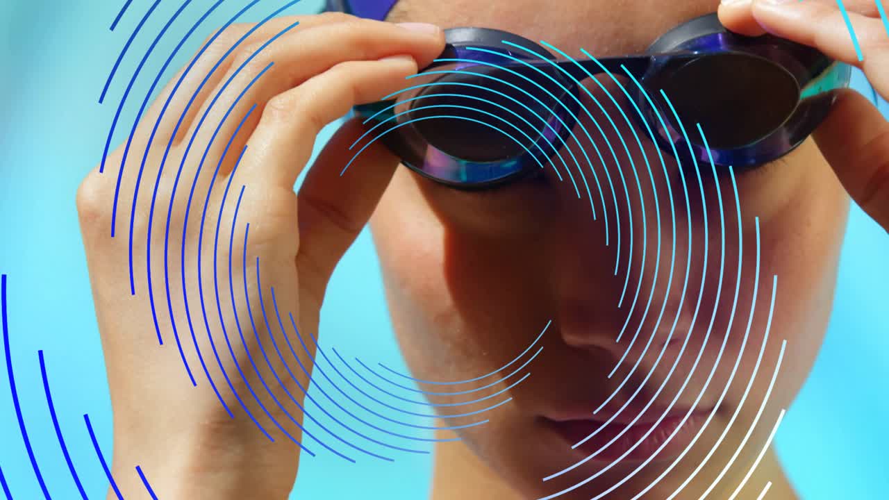 Female swimmer shifting gaze, pulling goggles down as rings cross face on blue backdrop, preparing