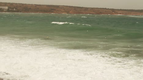 Waves-splashing-on-sea-dock-on-stormy-cloudy-windy-day-in-Mellieha,-Malta
