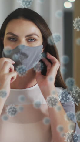 animation of virus cells over caucasian woman with face mask