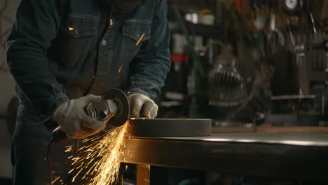 metalworker grinding metal in workshop