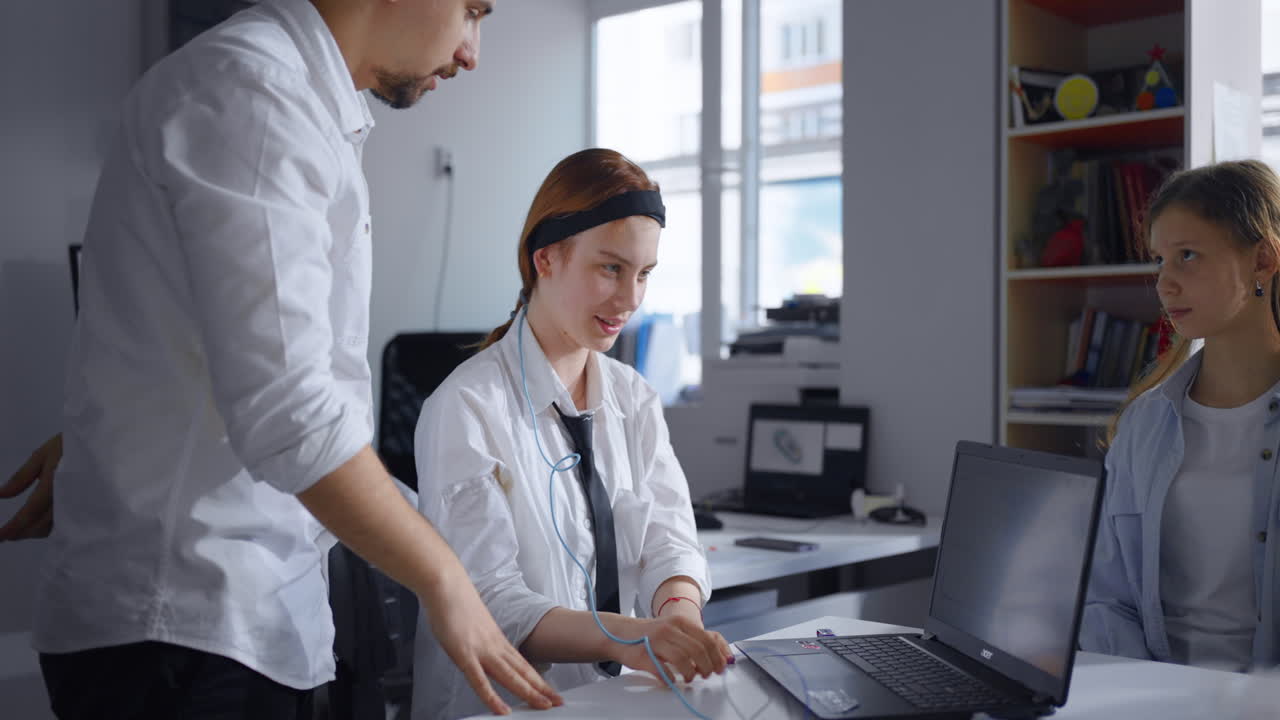 사무실에서 노트북을 통해 함께 일하는 세 명.